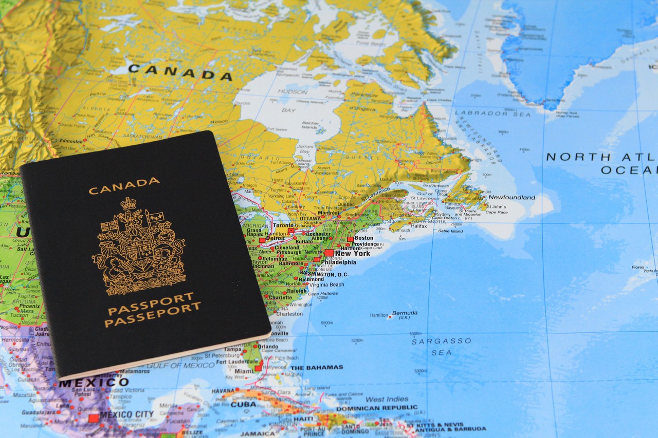 Canadian passport at the map of Canada