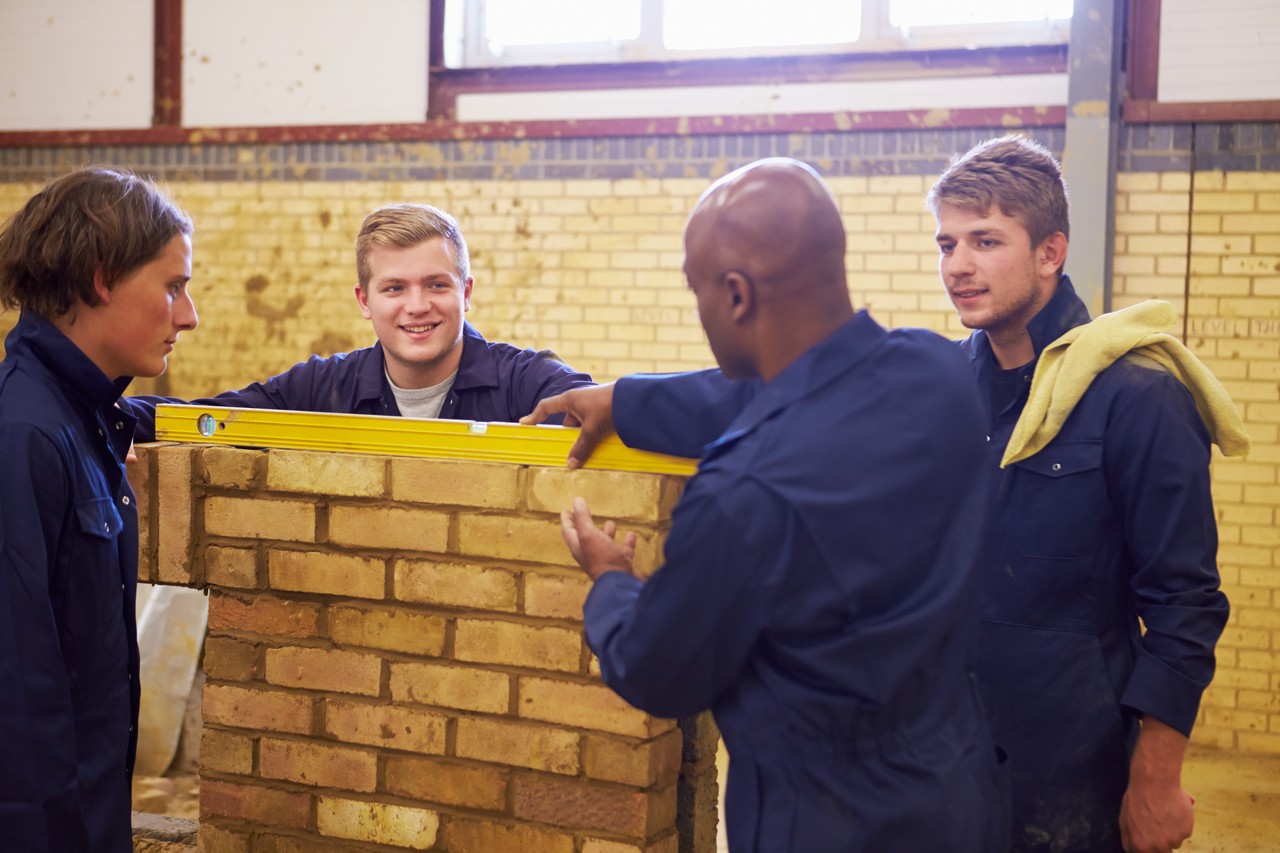 Teacher Helping Students Training To Be Builders