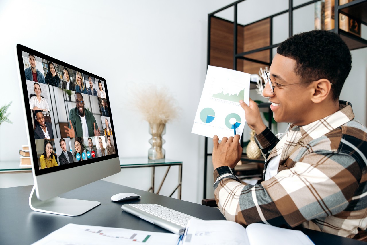 Distant online meeting, business negotiations. Hispanic young successful man, ceo or entrepreneur, communicates with his multiracial business team by video call, shows a graph, profit report